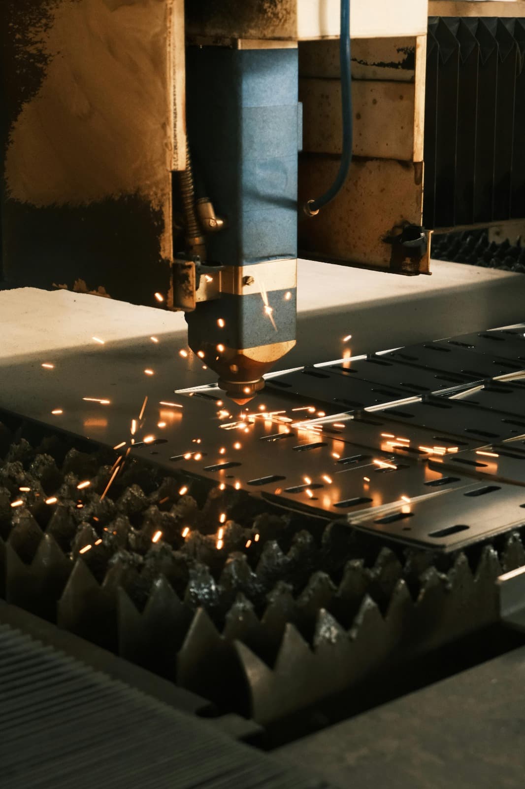 Laser Fiber w trakcie cięcia blachy stalowej — iskry i precyzyjna głowica laserowa